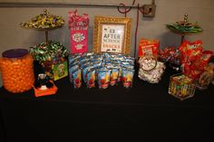 an assortment of candy and candies displayed on a black tablecloth with a gold frame