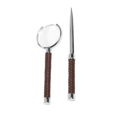 a pair of scissors sitting next to each other on a white surface with a brown handle