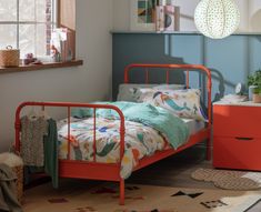 an orange metal bed frame in a child's bedroom