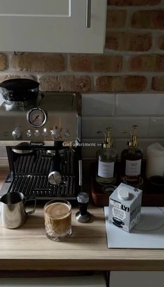 an espresso machine sitting on top of a counter next to bottles and cups