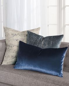 three pillows sitting on top of a couch