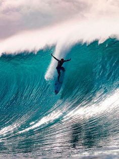 a man riding a wave on top of a surfboard in the middle of the ocean