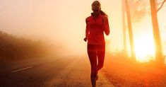 a woman running down the road at sunset