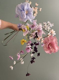 a person is holding a bouquet of flowers in their left hand and the flower stems are still attached to the vase