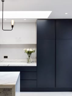 a kitchen with marble counter tops and blue cabinets