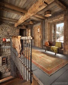 a living room filled with furniture and a cow hanging on the wall next to a metal fence