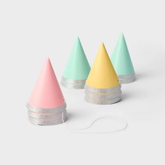 three pastel colored cones are sitting next to each other on a white surface and one is plugged into a charger