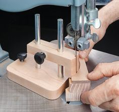 a person using a sewing machine to sew something on the wooden block with holes in it