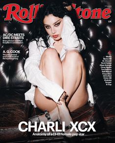 a woman sitting on top of a leather chair in front of a magazine cover with her legs crossed