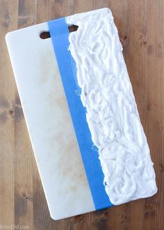 a white and blue cutting board sitting on top of a wooden table