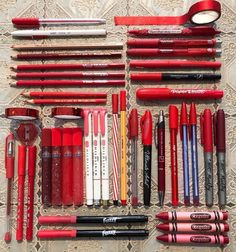 many different types of pens and pencils laid out on a table