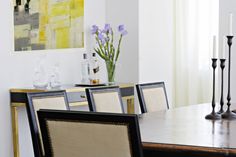 a dining room table with chairs and vases on it