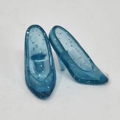 two blue shoes sitting on top of a white floor next to each other with water droplets all over them