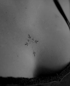 a black and white photo of a woman's breast with an arrow tattoo on it