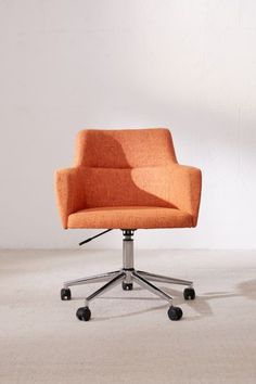 an orange office chair sitting on top of a white floor