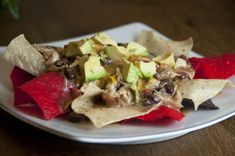 a white plate topped with nachos and fruit