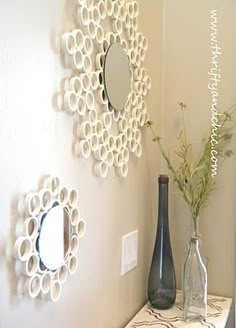 two vases are sitting on a shelf in front of a mirror and wall decoration