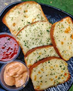 four slices of bread with cheese and sauces on a blue plate next to some ketchup