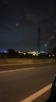 a blurry photo of the city lights from inside a car window at night time