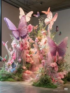 an arrangement of flowers and butterflies on display