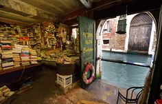 an open door to a room with books on the wall and water in the background