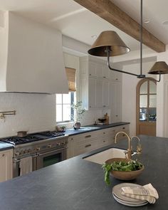 a kitchen with an island, stove and sink in it's centerpieces