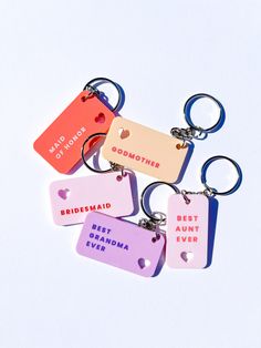 four keychains with different colored tags attached to each other on a white background