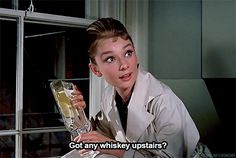 a woman holding a wine glass with the caption got any whiskey upstairs?