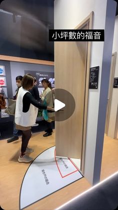 a group of people standing in front of a wooden door at an exhibit area with information on the walls