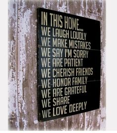 a wooden sign that says in this home we laugh