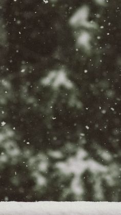 a black and white photo of snow falling