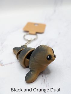 a keychain with a small brown animal on it's side and the words black and orange dual