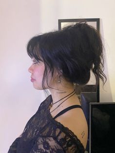 a woman with black hair is wearing a lace top and has her back turned to the camera