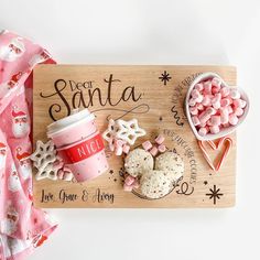 a wooden tray with cookies, marshmallows and a cup of coffee