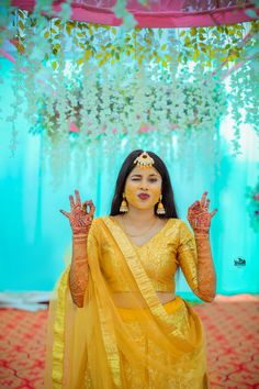 a woman dressed in yellow holding her hands up