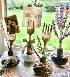 a table topped with different types of utensils and pictures next to a window