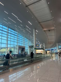 people are walking through an airport terminal with their luggage on the conveyor belt in front of them