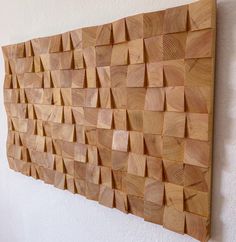 a wooden wall hanging on the side of a white wall