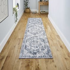 a white and blue rug on the floor in a hallway