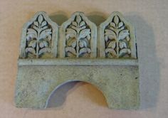 an old stone arch with decorative carvings on the top and bottom, sitting on a table