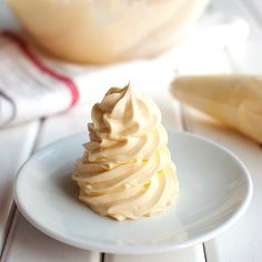 a white plate topped with whipped cream next to a bowl