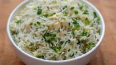 a white bowl filled with rice and green onions