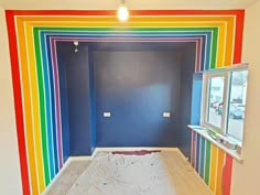 an empty room with rainbow painted on the walls