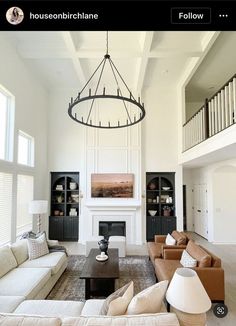 a living room filled with lots of furniture and a chandelier hanging from the ceiling