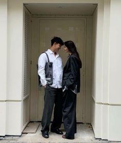 a man and woman standing in an open doorway