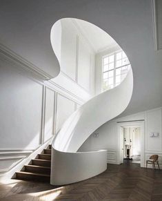 a white spiral staircase in an empty room