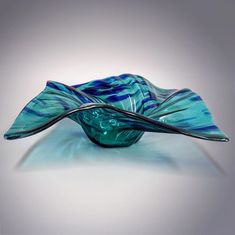 a blue glass bowl sitting on top of a table