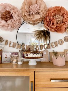 a table topped with a cake covered in paper flowers