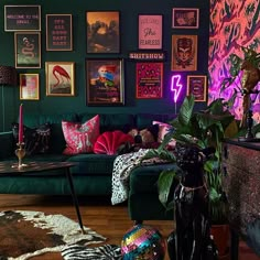 a living room filled with green couches and pictures on the wall above them,