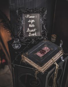 a sign that is sitting on top of a book shelf next to a candle and some books